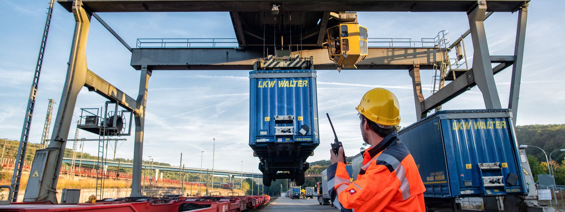 Container station with loading crane for truck trailers