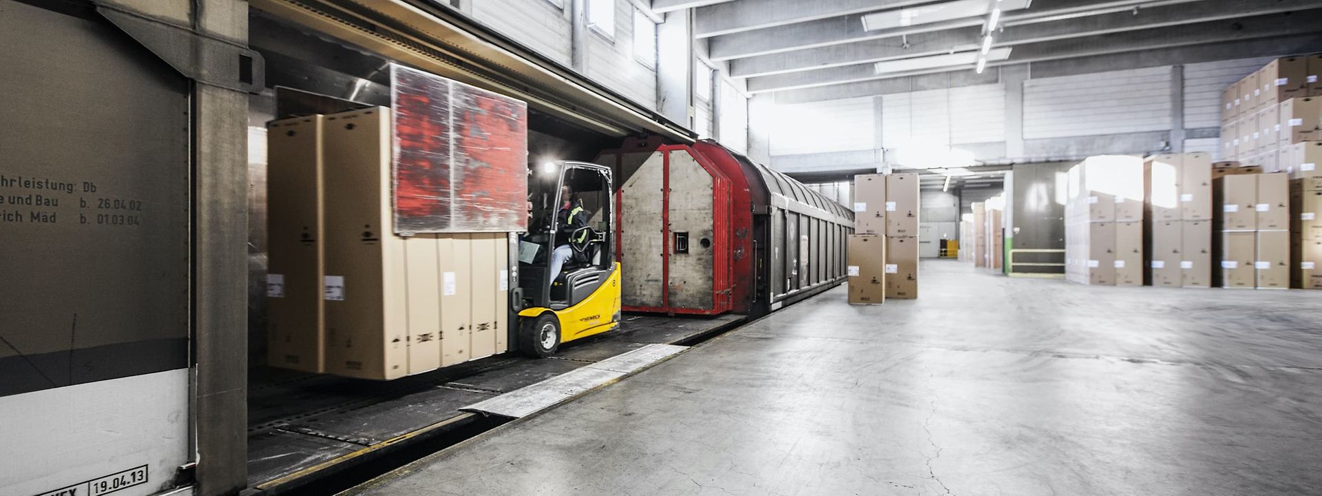 Forklift loads wagon with cardboard boxes